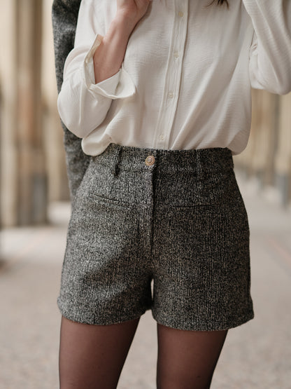 short structuré revisité, allure féminine audacieuse, coupe moderne droite courte, minimalisme graphique, style urbain assumé, pièce forte automne hiver, coton laine, short court, bouton bijoux, taille elastique
