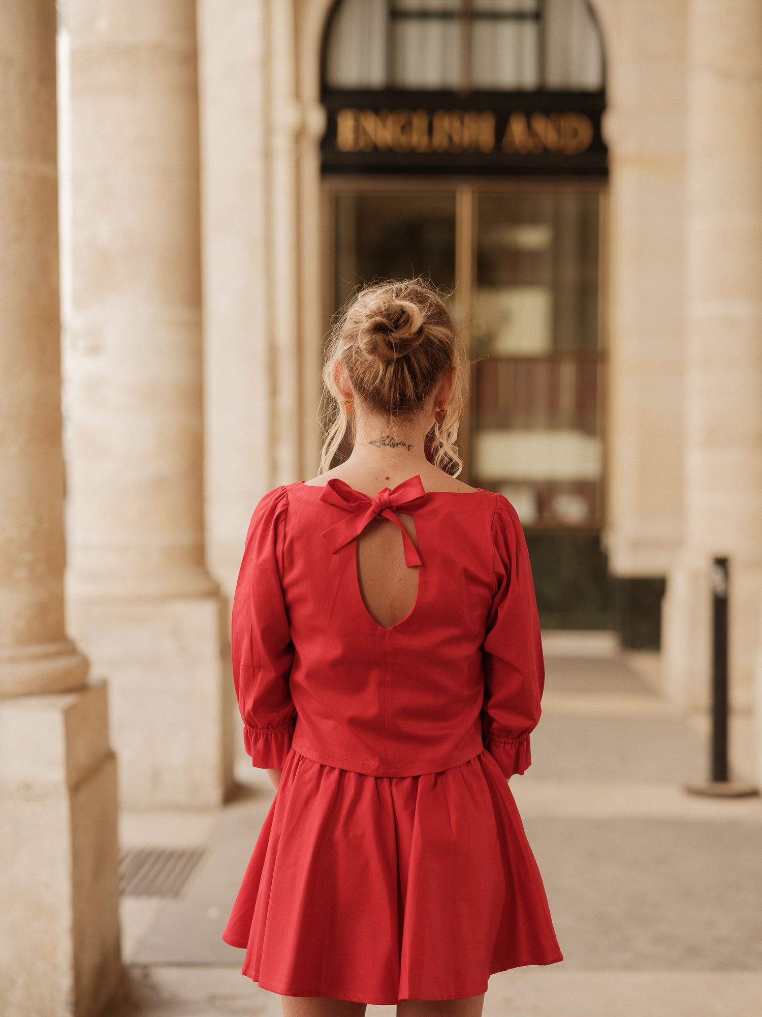 blouse femme structurée, top élégant, détail couture, féminité affirmée, fluidité raffinée, blouse rouge femme haut de gamme ANTIGONE, ANTIGONE Paris, marque de prêt-à-porter premium femme, tailleur femme élégant, ensemble coordonné chic, power suit féminin, ANTIGONE Paris, ANTIGONE, matching set