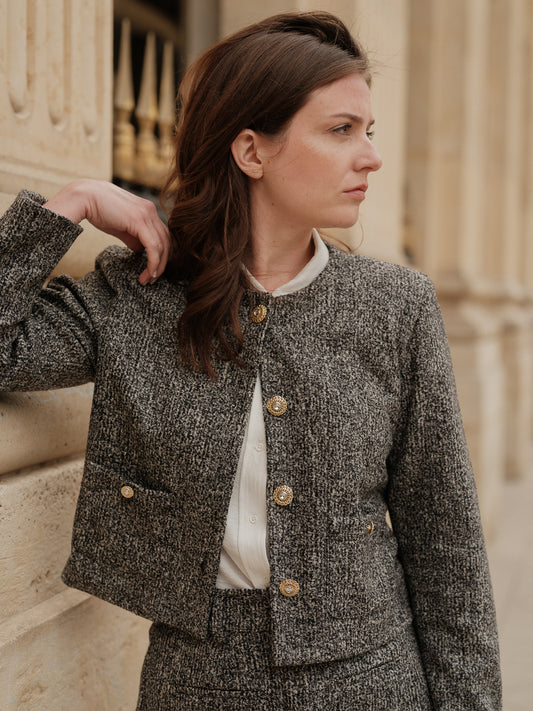 Veste courte structurée femme, silhouette forte, power tailoring, coupe droite élégante, veste urbaine raffinée, bouton bijoux, col rond, esprit Chanel ANTIGONE, ANTIGONE Paris, marque de prêt-à-porter premium femme, tailleur femme élégant, ensemble coordonné chic, power suit féminin, ANTIGONE Paris, ANTIGONE, matching set