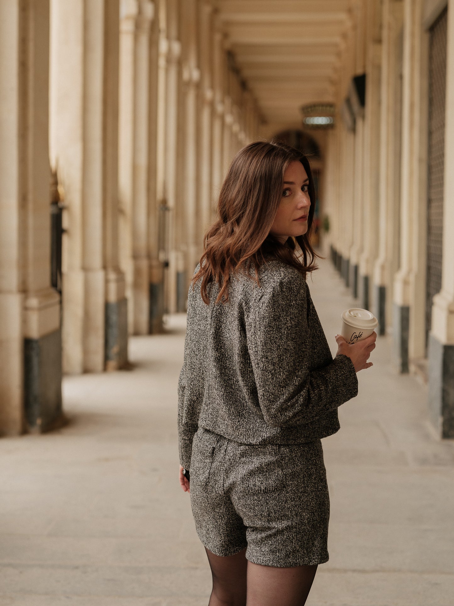 Veste courte structurée femme, silhouette forte, power tailoring, coupe droite élégante, veste urbaine raffinée, bouton bijoux, col rond, esprit Chanel ANTIGONE, ANTIGONE Paris, marque de prêt-à-porter premium femme, tailleur femme élégant, ensemble coordonné chic, power suit féminin, ANTIGONE Paris, ANTIGONE, matching set 