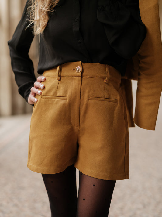 short structuré revisité, allure féminine audacieuse, coupe moderne droite courte, minimalisme graphique, style urbain assumé, pièce forte automne hiver, coton laine, short court, bouton bijoux ANTIGONE, ANTIGONE Paris, marque de prêt-à-porter premium femme, tailleur femme élégant, ensemble coordonné chic, power suit féminin, ANTIGONE Paris, ANTIGONE, matching set