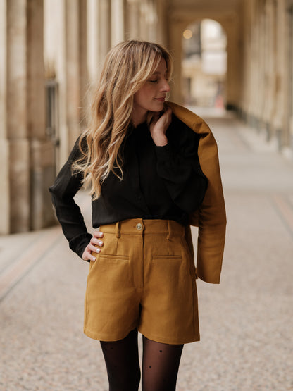 short structuré revisité, allure féminine audacieuse, coupe moderne droite courte, minimalisme graphique, style urbain assumé, pièce forte automne hiver, coton laine, short court, bouton bijoux ANTIGONE, ANTIGONE Paris, marque de prêt-à-porter premium femme, tailleur femme élégant, ensemble coordonné chic, power suit féminin, ANTIGONE Paris, ANTIGONE, matching set
