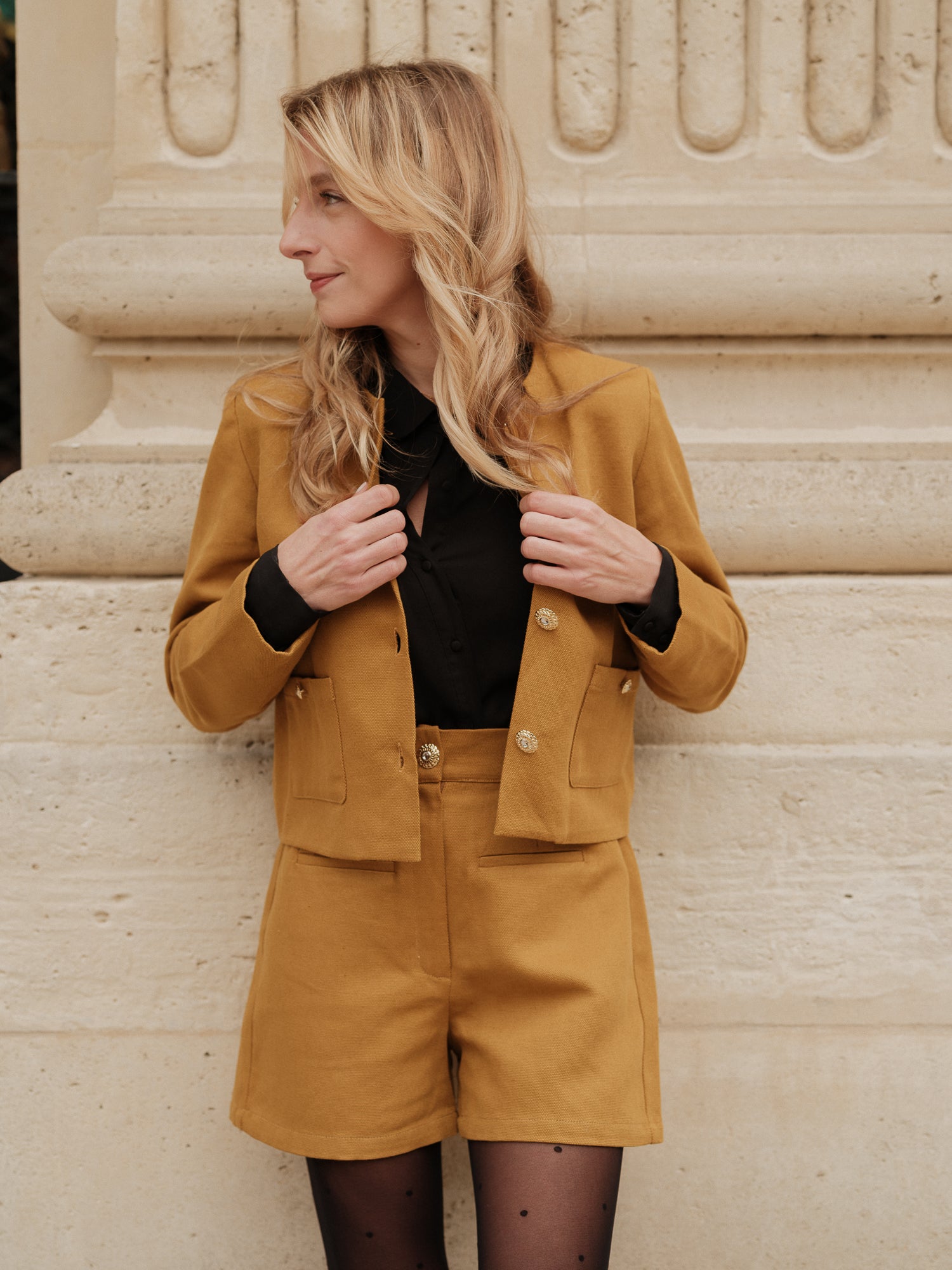 short structuré revisité, allure féminine audacieuse, coupe moderne droite courte, minimalisme graphique, style urbain assumé, pièce forte automne hiver, coton laine, short court, bouton bijoux ANTIGONE, ANTIGONE Paris, marque de prêt-à-porter premium femme, tailleur femme élégant, ensemble coordonné chic, power suit féminin, ANTIGONE Paris, ANTIGONE, matching set