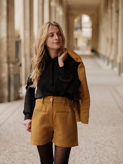 short structuré revisité, allure féminine audacieuse, coupe moderne droite courte, minimalisme graphique, style urbain assumé, pièce forte automne hiver, coton laine, short court, bouton bijoux ANTIGONE, ANTIGONE Paris, marque de prêt-à-porter premium femme, tailleur femme élégant, ensemble coordonné chic, power suit féminin, ANTIGONE Paris, ANTIGONE, matching set